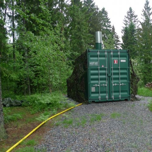 Containerised machine surrounded by forestry