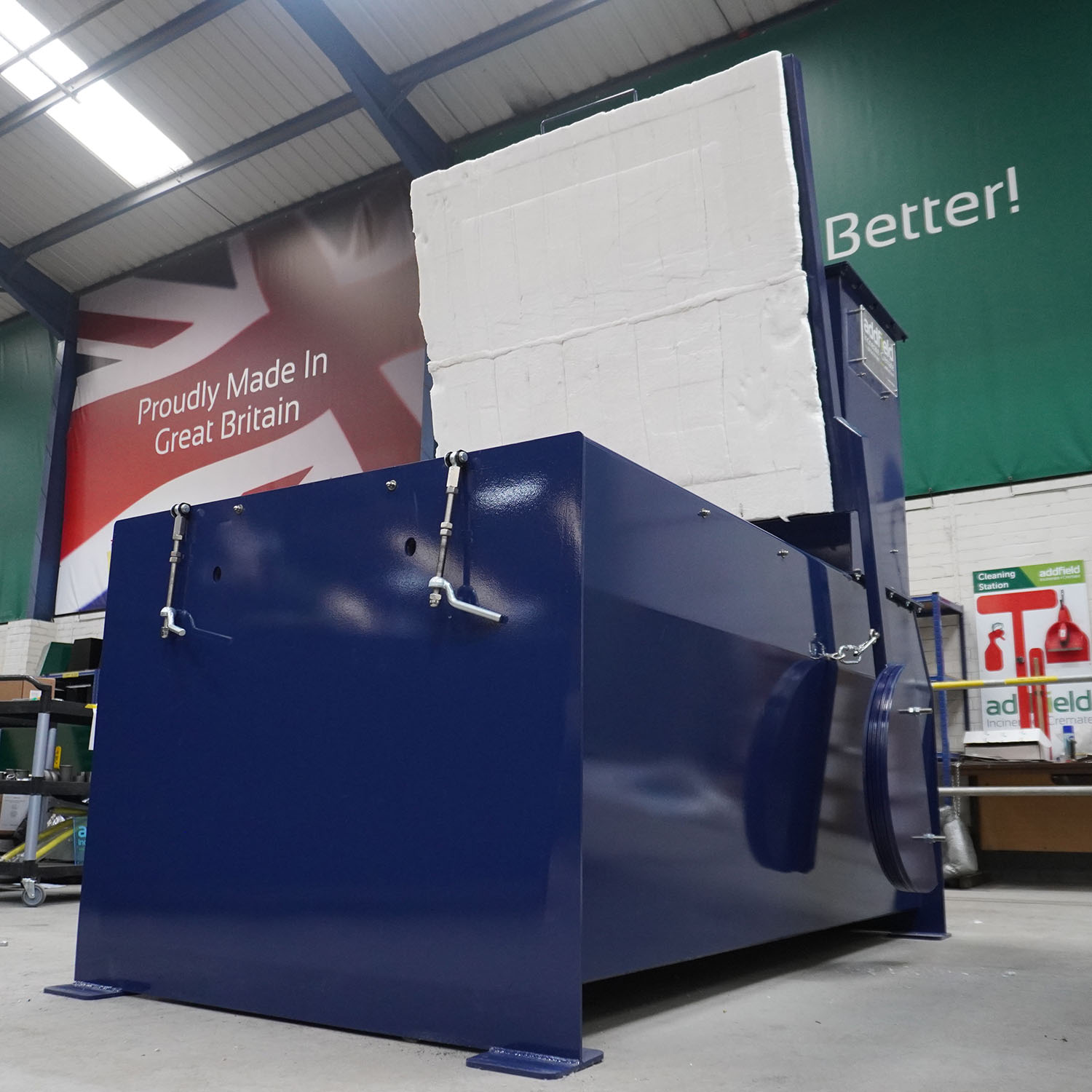 Low angle and lid open on blue marine incinerator infront of branding