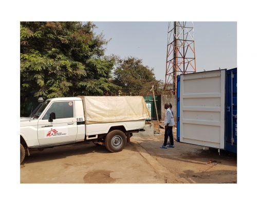 MSF delivery van next to blue container