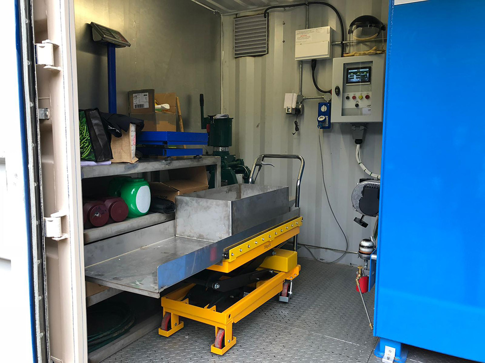 Containerised pet cremation machine with hydraulic lift table