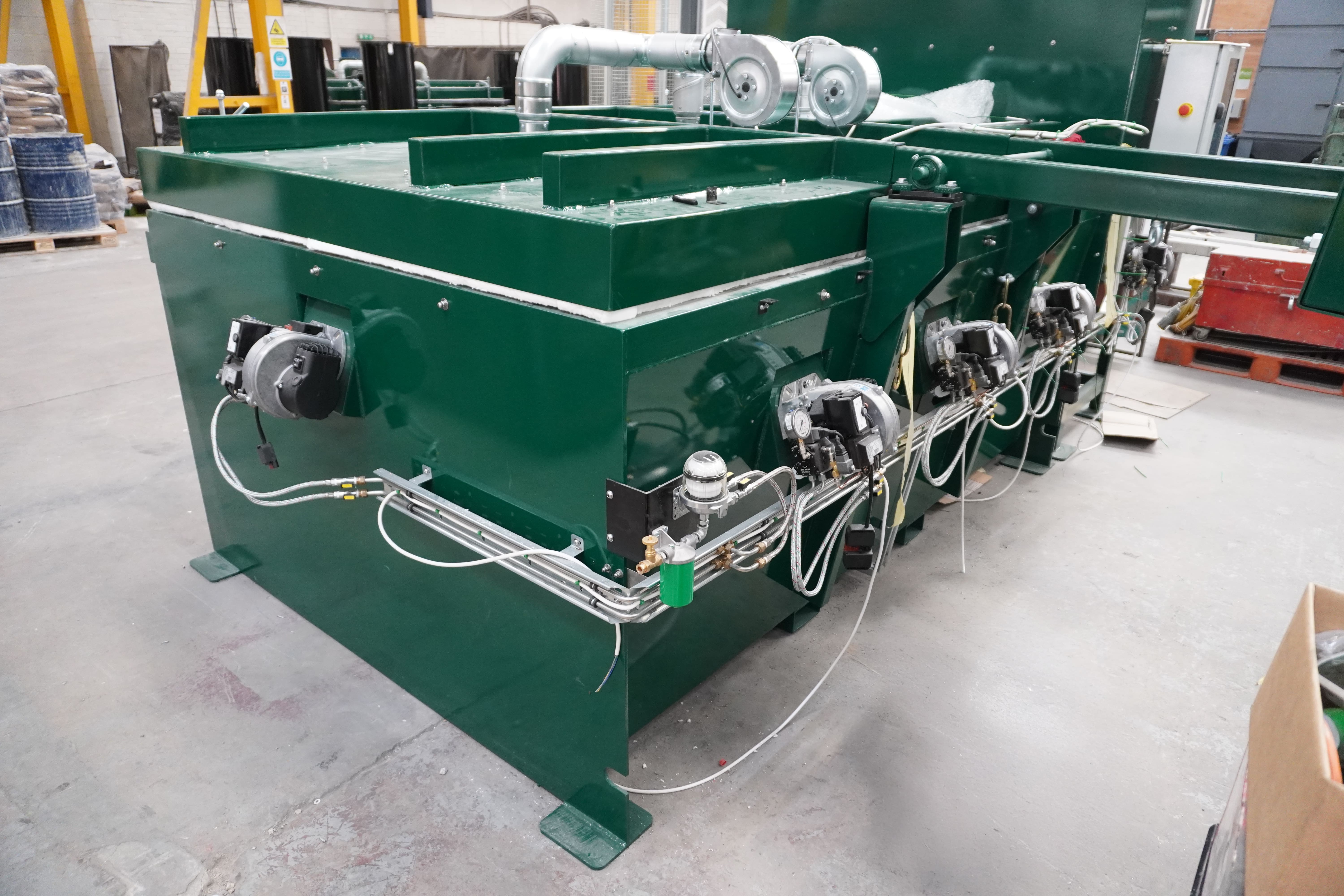 Wires and burners on back of large green cremator